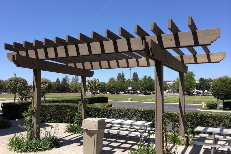 chairs and tables under uncovered pergolas